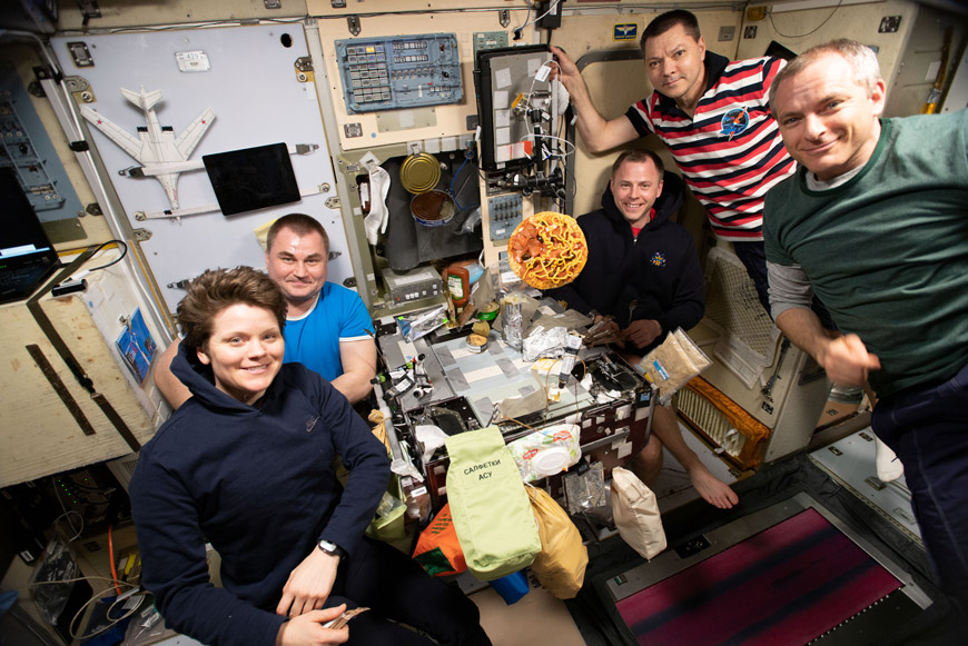Время обеда на Международной космической станции. Пять членов экипажа 60-й экспедиции МКС за обеденным столом в модуле «Звезда». 2019 г. (фото NASA)