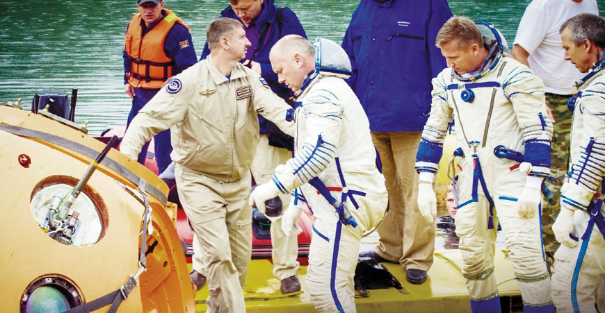 Тренировка начинается: космонавты Сергей Прокопьев и Олег Артемьев и астронавт Эндрю Фойстел, облаченные в скафандры «Сокол», готовятся занять свои места в спускаемом аппарате